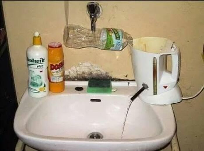 A makeshift faucet setup using a plastic bottle above a sink, showcasing Slavic Science.