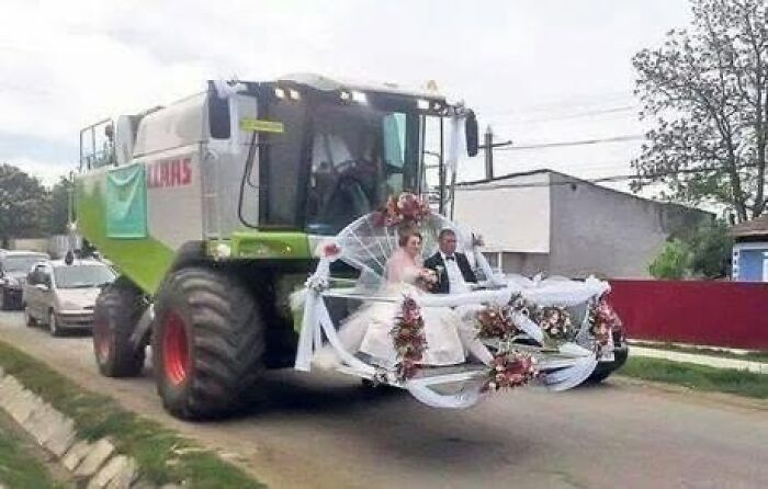 A bride and groom in a decorated combine harvester, a unique wedding transport showcasing Slavic Science.
