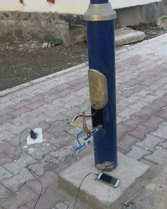 An example of Slavic science: exposed wiring on a street lamp used to charge a cell phone, highlighting resourceful power solutions.