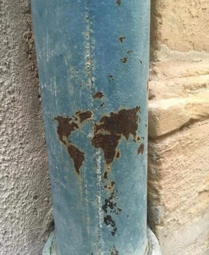 Rust on a blue pipe naturally forms a world map, a unique sight among the great photos that became Internet legends.