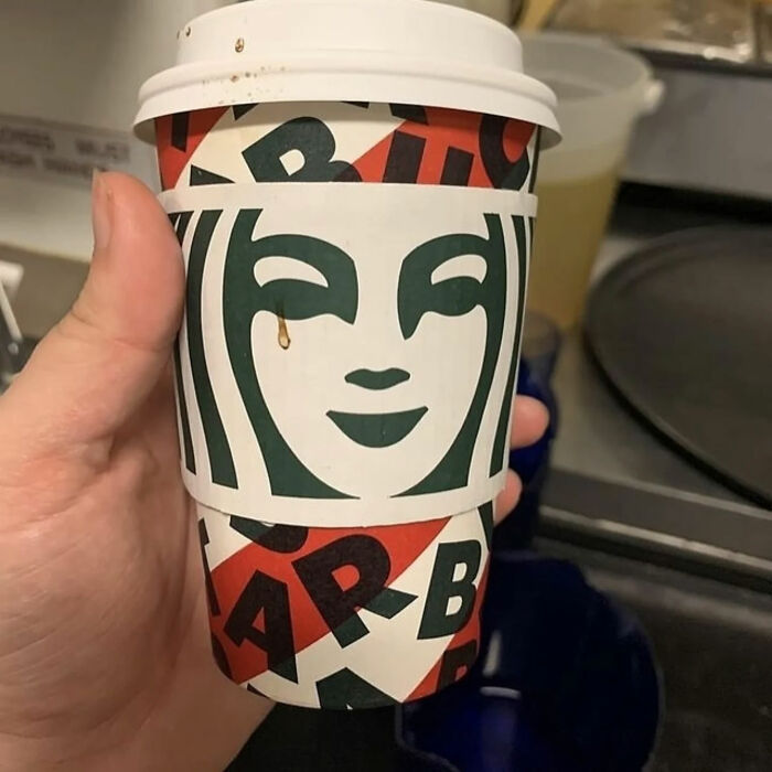 A hand holding a Starbucks cup with a coffee spill resembling a tear, a great photo that became a legend.