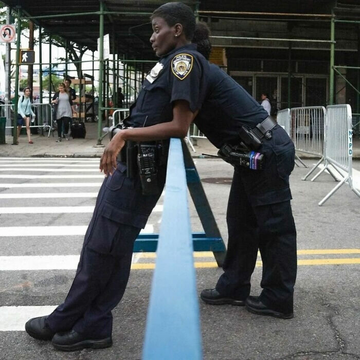 Two police officers leaning on a blue barrier, captured in a photo that became a legend of the internet.