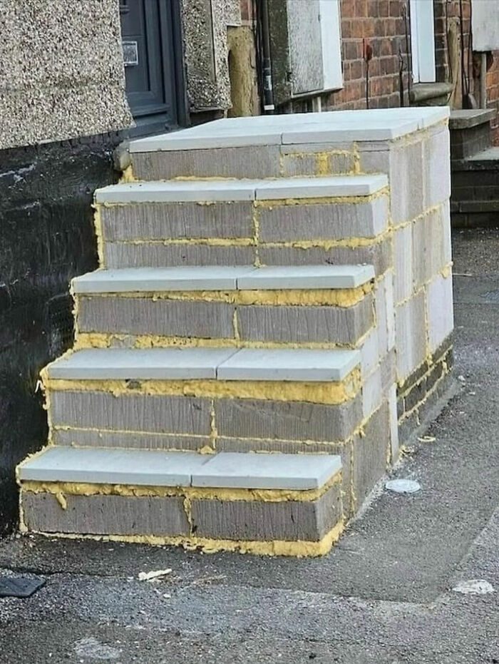 A set of concrete stairs with bright yellow insulation showing between the blocks, a legend of the internet.
