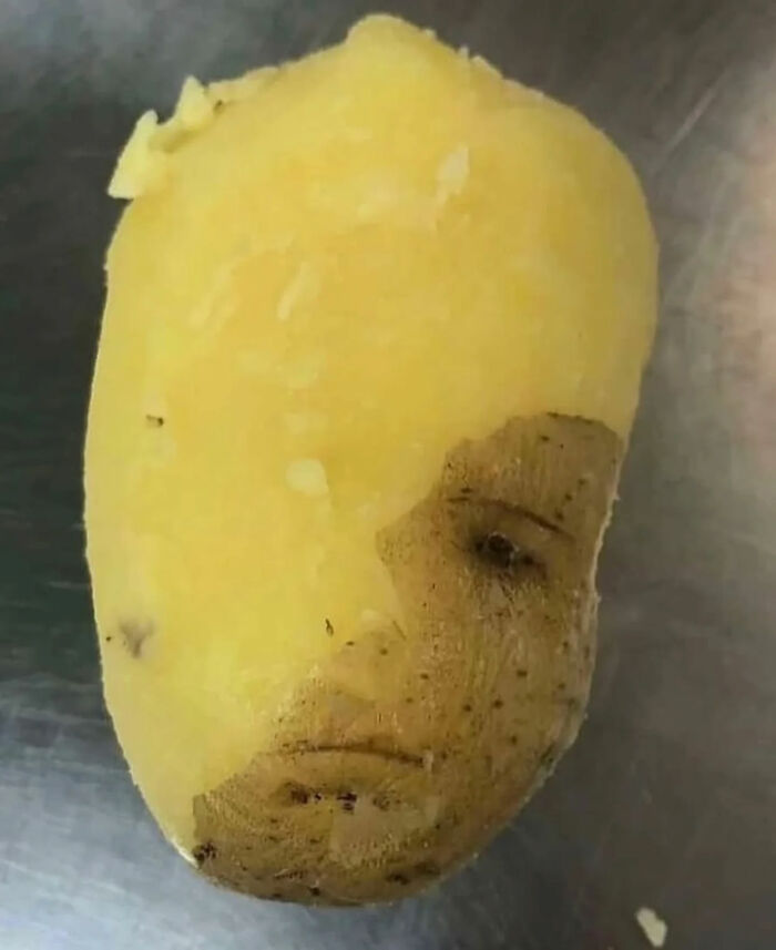 A potato with a face partially peeled, resembling a person, a great photo and legend of the Internet.