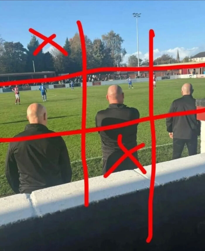 Three men watching a soccer game with red tic-tac-toe lines drawn over them, a great photo.