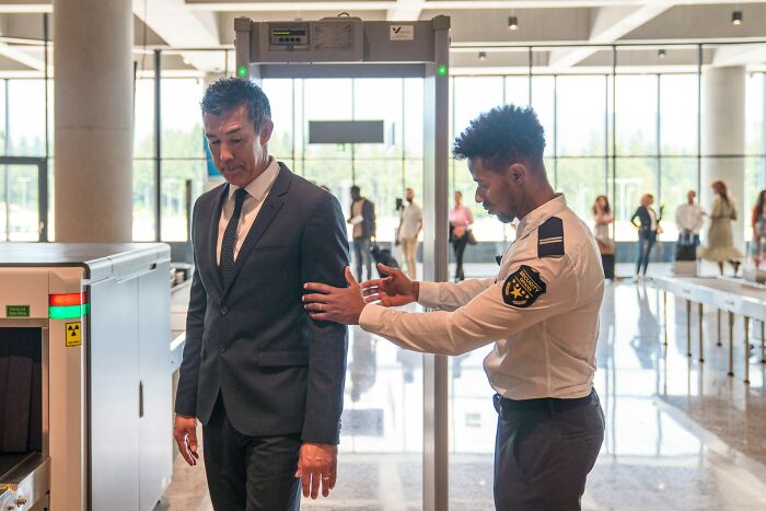 A man in a suit is patted down by security, illustrating a scene from a wild courtroom story.