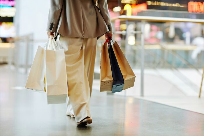 Person carrying multiple shopping bags symbolizing shopping conveniences