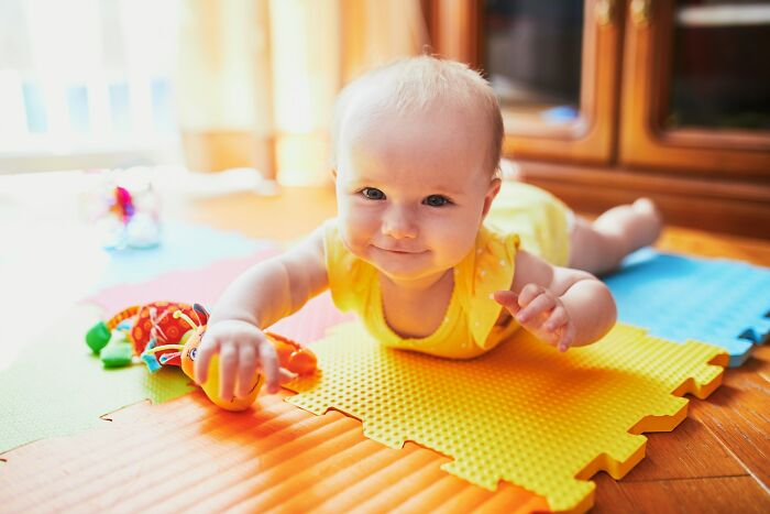 Smiling baby lying on playmat, unrelated to shocking partner phone findings