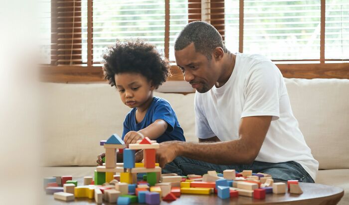 Father and child playing with wooden blocks focusing on early literacy skills