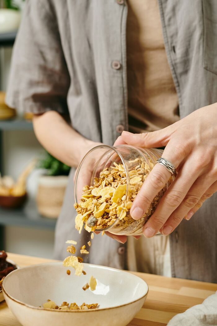 Person pouring granola cereal into a bowl with food facts theme