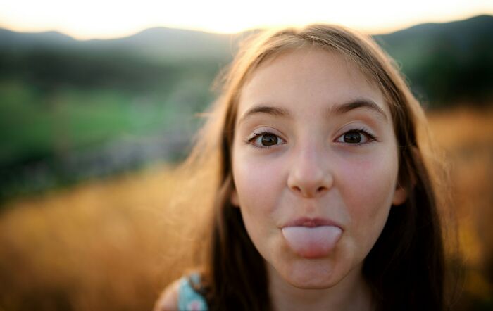 Close-up of girl sticking out tongue outdoors illustrating human body facts