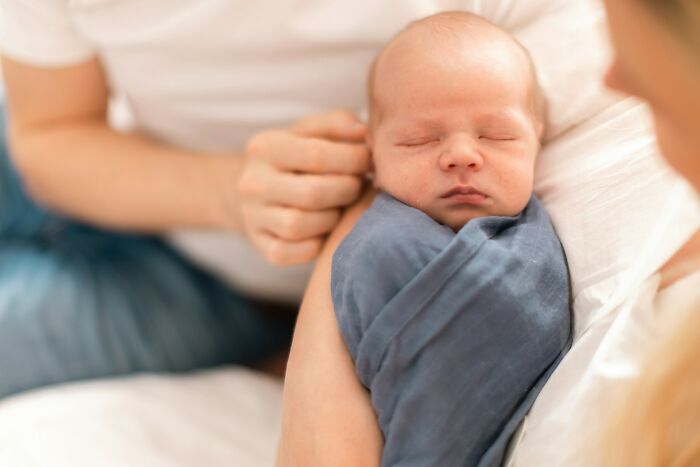 Close-up of newborn baby wrapped in blanket symbolizing shocking partner phone revelations