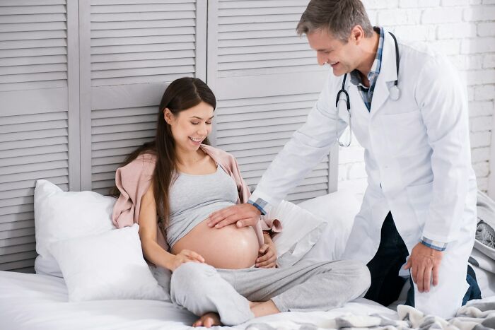 Doctor examining pregnant woman's belly during prenatal checkup