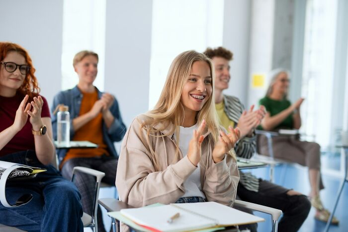 Students clapping in classroom with class clown consequences context