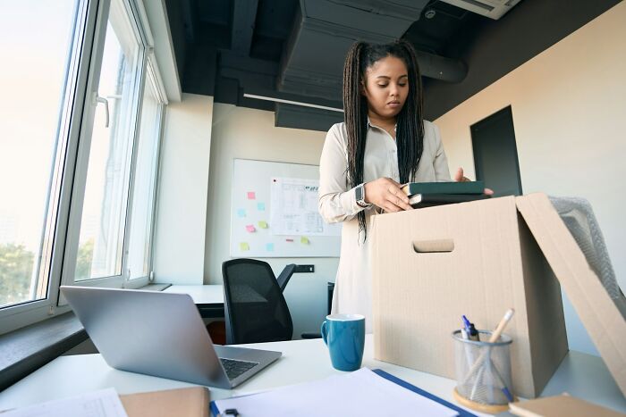 Woman packing boxes in office symbolizing mass walkouts