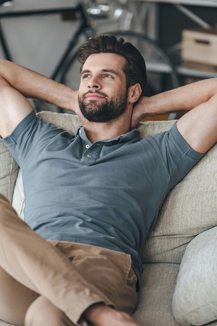 A man relaxing on a couch, highlighting the comfort of human bodies.