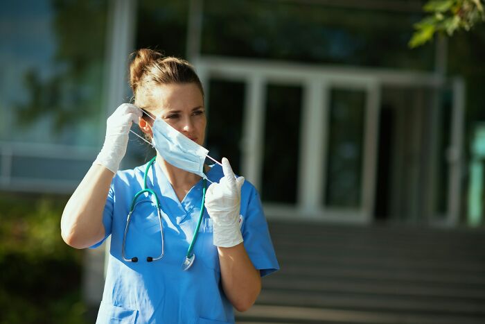 Nurse removing mask outside hospital representing healthcare walkouts