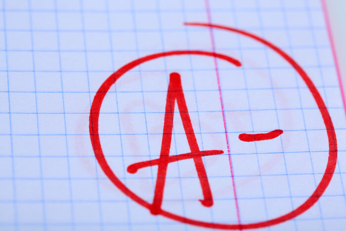 A close-up of a student's paper with a red A- circled, representing grades teachers give to students.