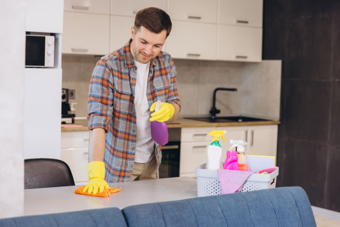 A man cleaning a table in the kitchen, illustrating things people never tell their partners.