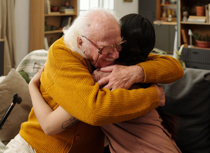 An elderly man hugging a younger person, illustrating things partners never tell each other.
