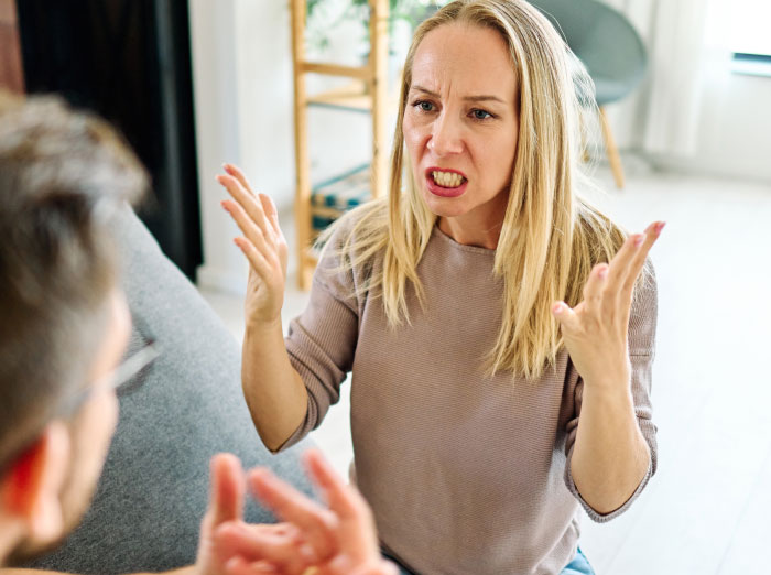 A woman angrily gesturing during an argument with a man, depicting secret things partners might hide.