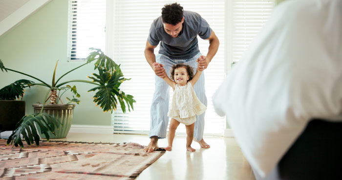 A father helping his young daughter walk, representing things partners keep from each other.