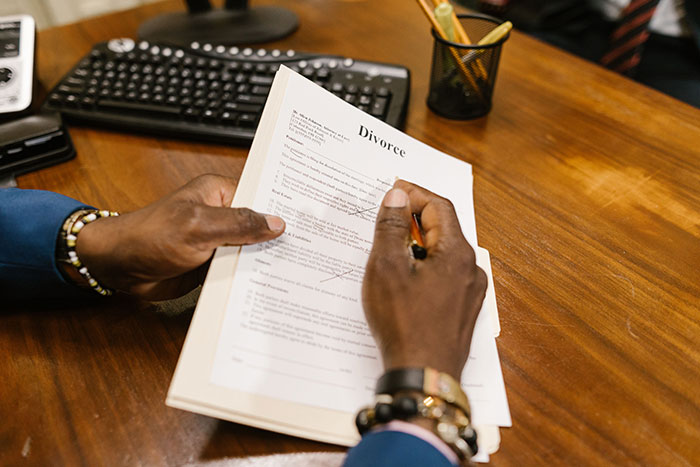 A person signs a postnup, signaling a potential divorce and end to years of marriage. A person signs a postnup, signaling a potential divorce and end to years of marriage.