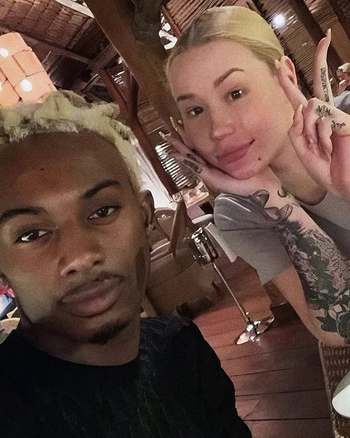 Iggy Azalea with a man posing for a selfie indoors Iggy Azalea with a man posing for a selfie indoors