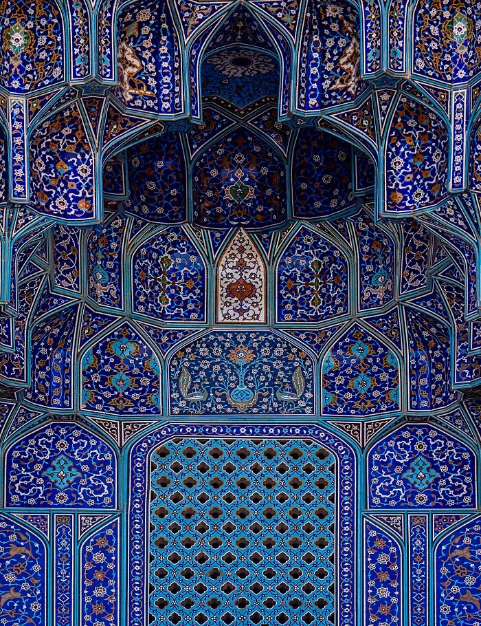 Intricate blue Persian tilework featuring floral and geometric designs on mosque architecture