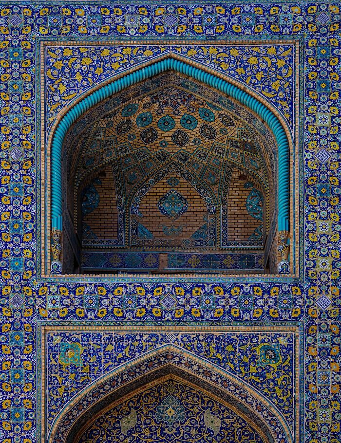 Persian mosque arch decorated with detailed blue and yellow geometric tiles