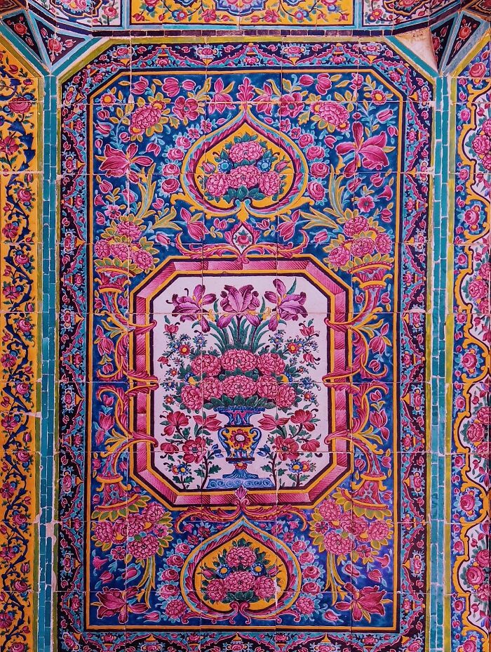 Intricate floral patterns on vibrant classical Persian tiles with rich colors and geometric borders