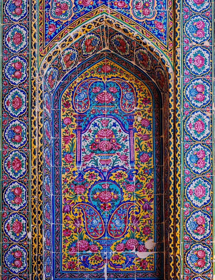 Colorful floral classical Persian tile art in an arched niche showcasing traditional geometric designs