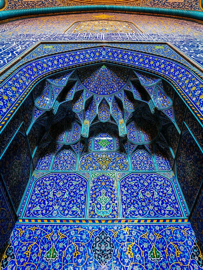 Detailed blue geometric Persian tilework covering mosque archway
