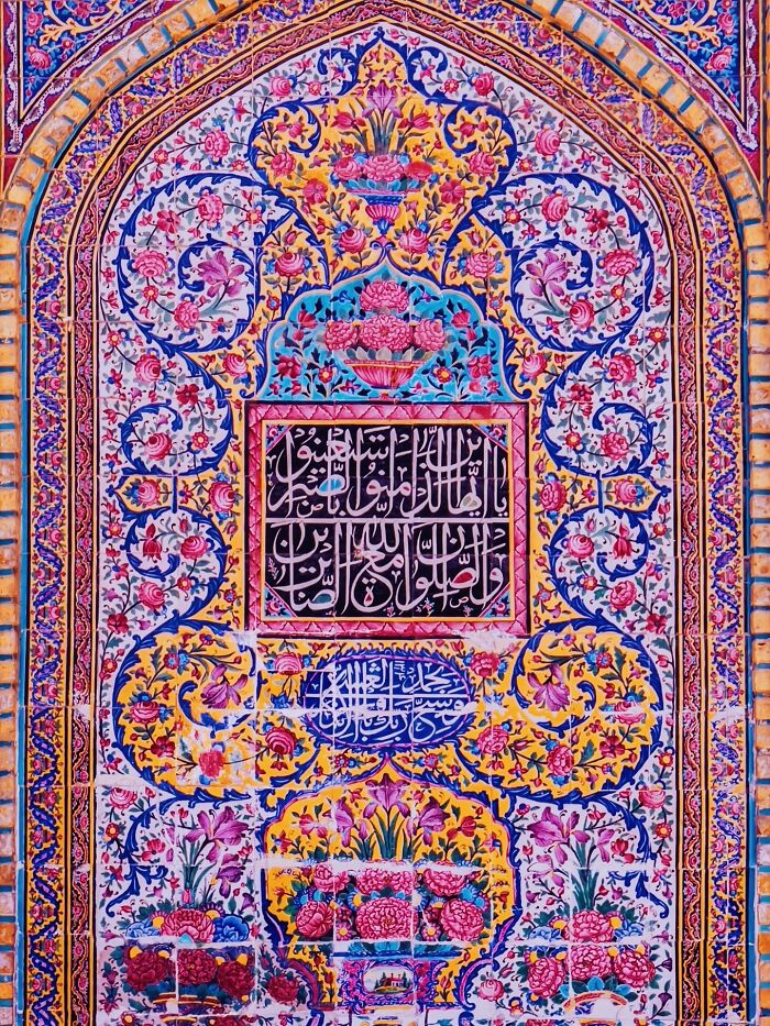 Colorful Persian floral and calligraphy tilework on arched wall panel