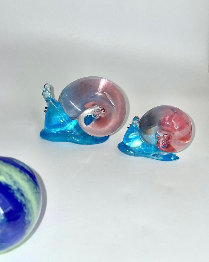 Japanese artist creates hyper-realistic glass food, showcasing two colorful glass snails.