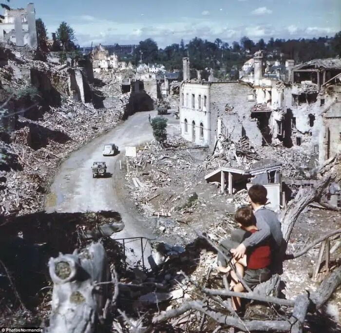 Historical photos: Two boys looking at a war-torn town with destroyed buildings and rubble.