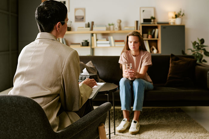 Therapist consulting with a young woman about allergy and family issues
