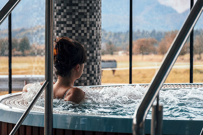 A person relaxes in a bubbling hot tub with a scenic view. Industry secrets customers were never meant to hear.