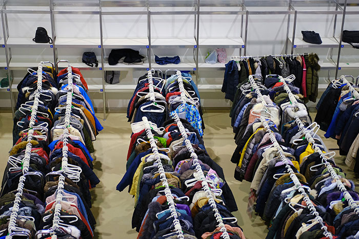 Rows of coats on hangers fill a large room, exposing industry secrets customers were never meant to hear.