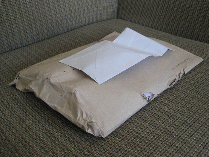 A small white envelope sits atop a larger, wrapped brown package, hinting at industry secrets customers were never meant to hear.