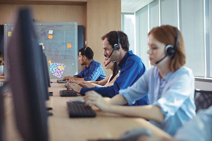 Customer service representatives with headsets work at computers in an office. Industry secrets customers were never meant to hear.