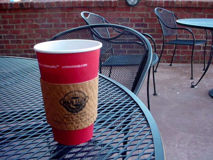 A red coffee cup on an outdoor cafe table, hinting at industry secrets within the food and beverage sector.