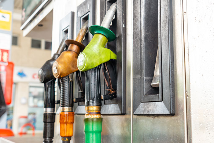 Fuel nozzles at a gas station, highlighting industry secrets customers were never meant to hear about flight costs.