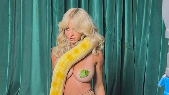 Sydney Sweeney posing topless with yellow snake prop behind curtains Sydney Sweeney posing topless with yellow snake prop behind curtains