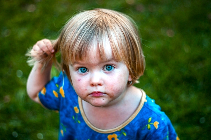 Close-up of toddler with blue eyes outdoors