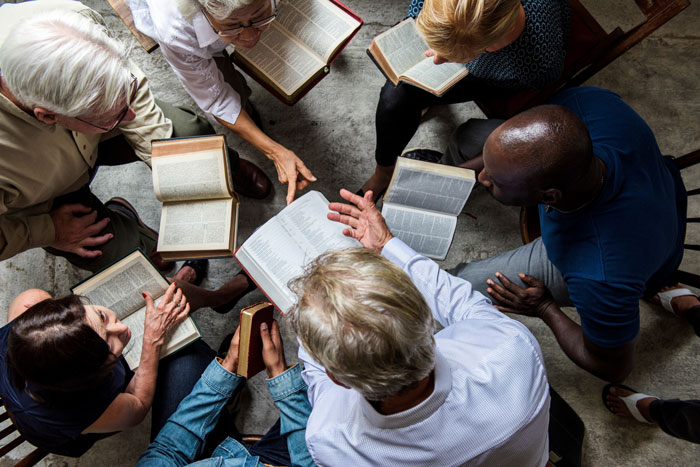 A group studies open books, discussing ancient Roman writings and the historical evidence that Jesus was a real person. A group studies open books, discussing ancient Roman writings and the historical evidence that Jesus was a real person.