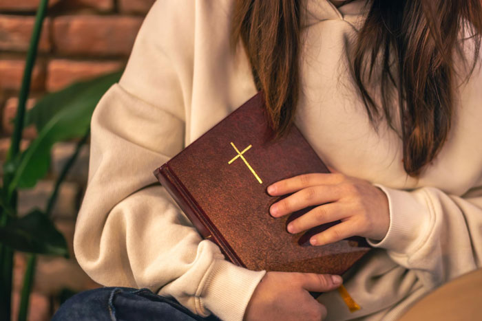 A person holds a Bible, representing faith connected to ancient Roman writings and the historical evidence of Jesus. A person holds a Bible, representing faith connected to ancient Roman writings and the historical evidence of Jesus.