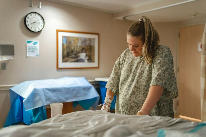 Pregnant woman distressed in hospital room after infidelity news