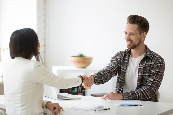 Man unjustly fired for stealing $361, shakes hands with woman in an office setting. Revenge story begins.