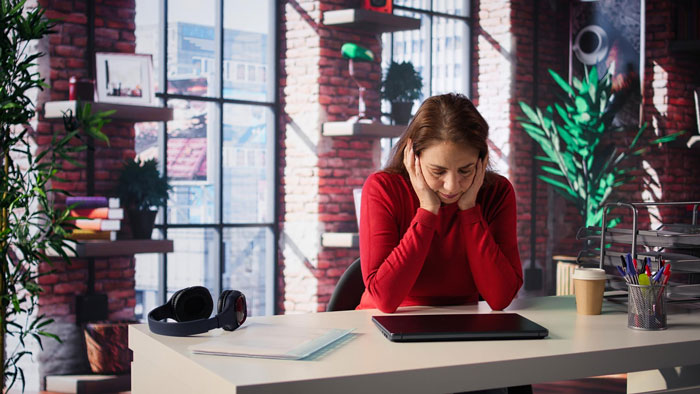 A person looking distraught at a desk after being unjustly fired for stealing $361.